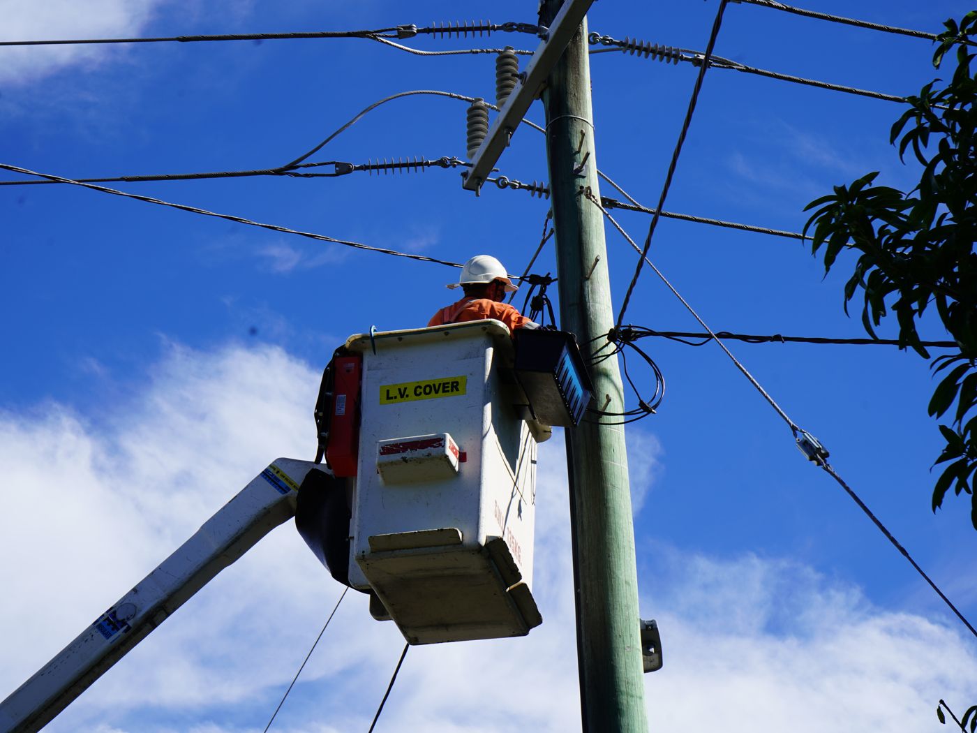 Intellergy crew member working from an elevated work platform at a power pole
